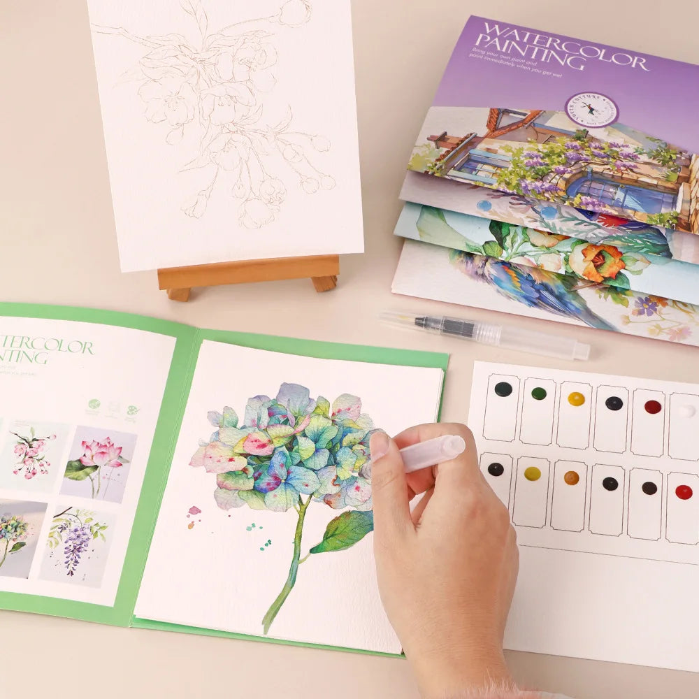 Set creativo di acquerelli con carta, penna immersione e pigmenti